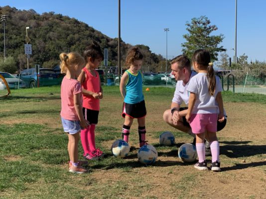 kids soccer class with their soccer coach. Girls soccer class