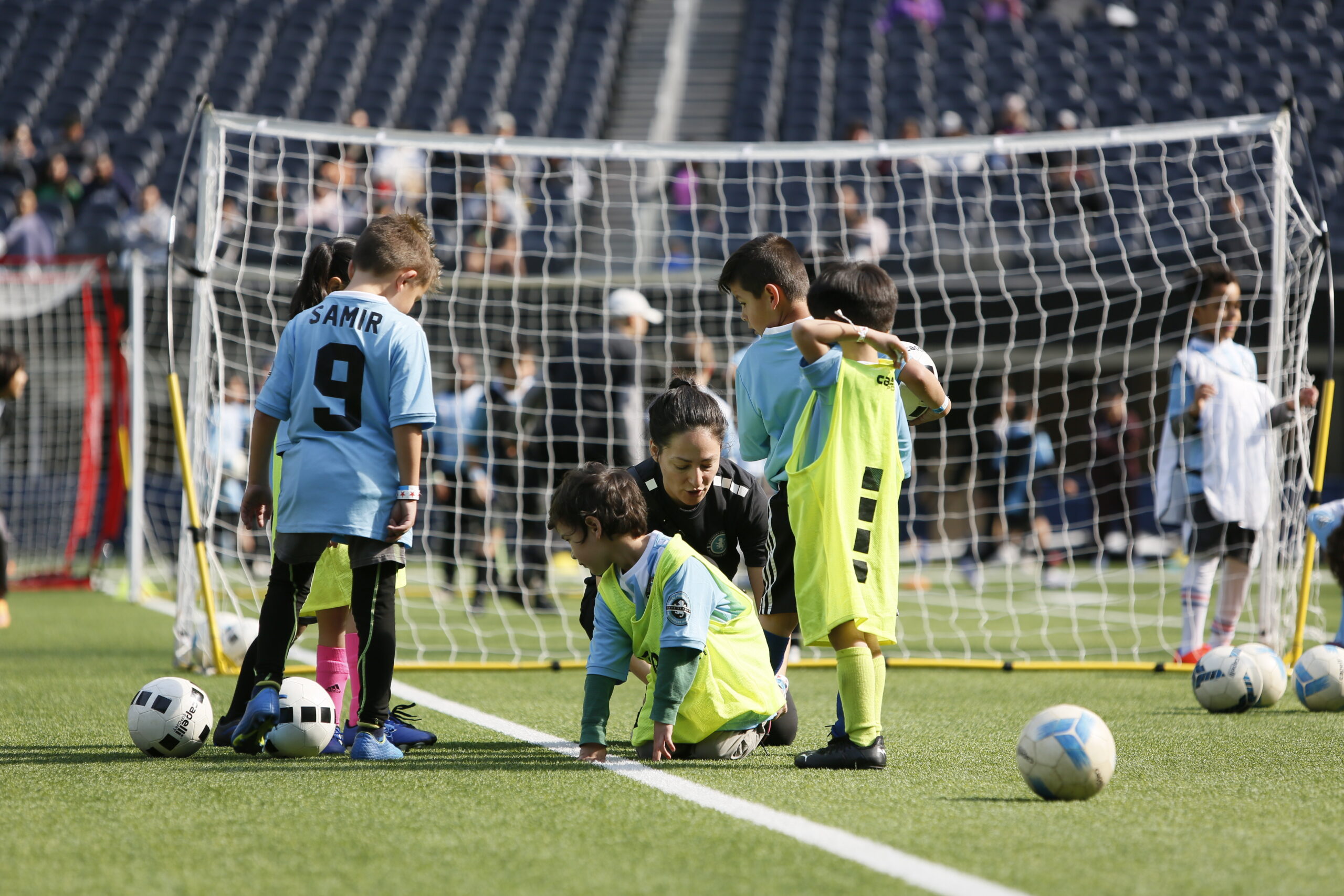 soccer coach teaching her soccer players. boy and girl soccer players at a soccer class with their professional soccer coach